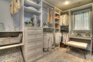 Design ideas for a mid-sized transitional women's walk-in wardrobe in New York with carpet, multi-coloured floor, grey cabinets and recessed-panel cabinets.