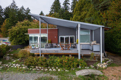 Mid-sized minimalist backyard concrete paver patio kitchen photo in Seattle with a roof extension