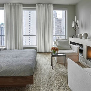 Großes Modernes Hauptschlafzimmer mit grauer Wandfarbe, Kaminumrandung aus Beton, Teppichboden und Kamin in Chicago