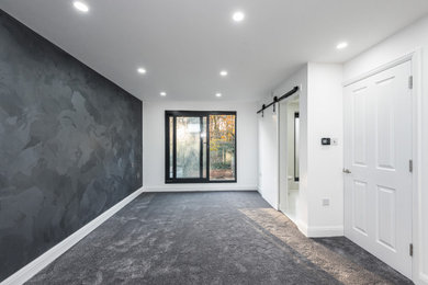 Design ideas for a medium sized modern master bedroom in Essex with grey walls, carpet, grey floors and a feature wall.