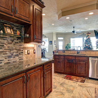 This is an example of a small traditional galley kitchen pantry in Houston with raised-panel cabinets, medium wood cabinets, granite benchtops, brown splashback, glass tile splashback, stainless steel appliances, porcelain floors and no island.