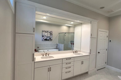 Freestanding bathtub - large traditional master white tile and porcelain tile porcelain tile, multicolored floor and double-sink freestanding bathtub idea in Cincinnati with shaker cabinets, white cabinets, a two-piece toilet, beige walls, a drop-in sink, quartz countertops, a hinged shower door, white countertops, a niche and a built-in vanity