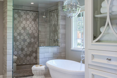 Inspiration for a traditional bathroom in San Francisco with recessed-panel cabinets, white cabinets, a freestanding tub, gray tile and grey walls.