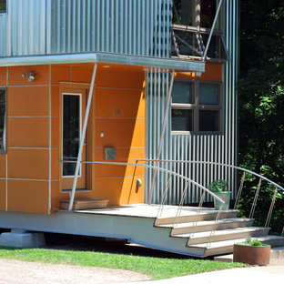 Bild på ett funkis oranget hus, med blandad fasad