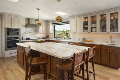 Kitchen pantry - mid-sized transitional l-shaped light wood floor and beige floor kitchen pantry idea in San Diego with an undermount sink, shaker cabinets, medium tone wood cabinets, quartzite countertops, beige backsplash, ceramic backsplash, stainless steel appliances, an island and white countertops