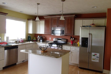 Mid-sized elegant l-shaped light wood floor and brown floor eat-in kitchen photo in Grand Rapids with a double-bowl sink, shaker cabinets, white cabinets, granite countertops, stainless steel appliances and an island