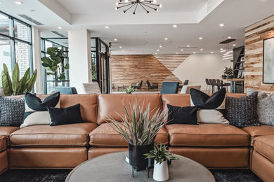 Huge trendy open concept porcelain tile, gray floor and wood wall living room photo in Grand Rapids with beige walls