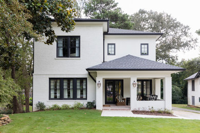 Réalisation d'une façade de maison blanche tradition à un étage avec un toit à quatre pans, un toit en shingle et un toit gris.
