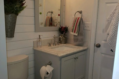 Inspiration for a mid-sized transitional 3/4 terra-cotta tile cement tile floor and beige floor alcove shower remodel in Boston with shaker cabinets, a two-piece toilet, beige walls, an undermount sink, quartzite countertops, a hinged shower door and white countertops