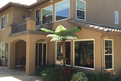 Mid-sized mediterranean brown two-story stucco gable roof idea in San Diego