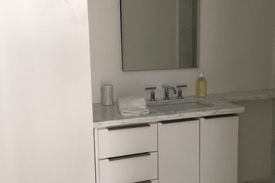 Bathroom - mid-sized modern kids' gray tile and ceramic tile ceramic tile bathroom idea in New Orleans with flat-panel cabinets, white cabinets, white walls, an undermount sink and marble countertops
