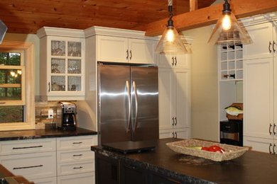 Inspiration for a mid-sized rustic u-shaped terra-cotta tile kitchen remodel in Toronto with recessed-panel cabinets, white cabinets, granite countertops, beige backsplash, stone tile backsplash, stainless steel appliances, an island and a double-bowl sink