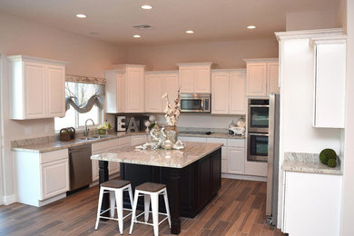Mid-sized transitional u-shaped porcelain tile open concept kitchen photo in Phoenix with a double-bowl sink, raised-panel cabinets, white cabinets, granite countertops, gray backsplash, stone slab backsplash, stainless steel appliances and an island