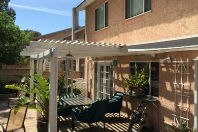 Example of a mid-sized classic backyard patio design in Los Angeles with decking and a pergola