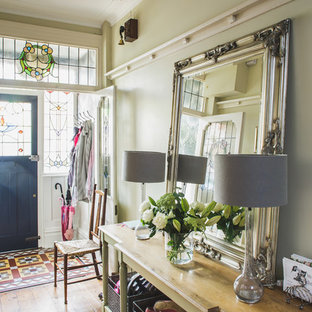 Ispirazione per un ingresso o corridoio classico con pareti verdi, pavimento in legno massello medio, una porta singola e una porta nera