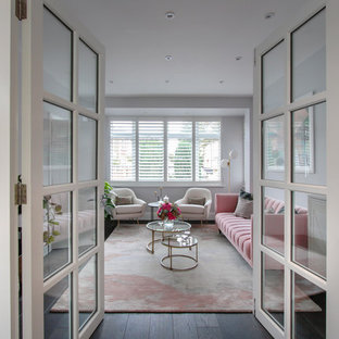 Photo of a medium sized contemporary enclosed living room in London with a home bar, white walls and dark hardwood flooring.