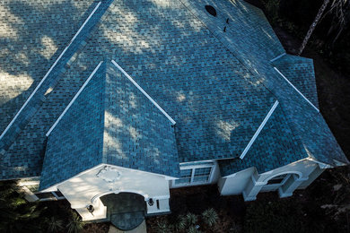 Modelo de fachada de casa beige tradicional grande de una planta con revestimiento de estuco, tejado a dos aguas y tejado de teja de madera