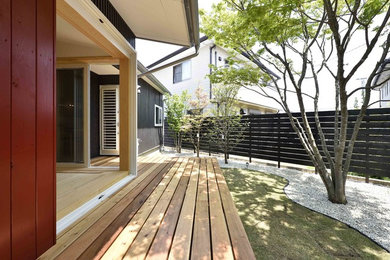 他の地域にあるお手頃価格の広い、夏のアジアンスタイルのおしゃれな横庭 (屋外コート、日向、デッキ材舗装) の写真