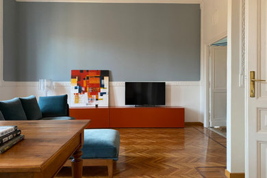 Esempio di un soggiorno moderno di medie dimensioni e aperto con pareti blu e parquet chiaro