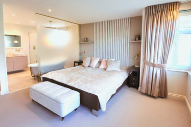 Large trendy master carpeted and beige floor bedroom photo in London with beige walls
