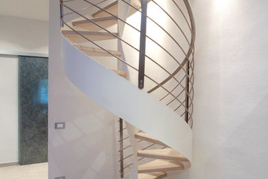 Photo of a small modern wood spiral staircase in Florence with open risers.