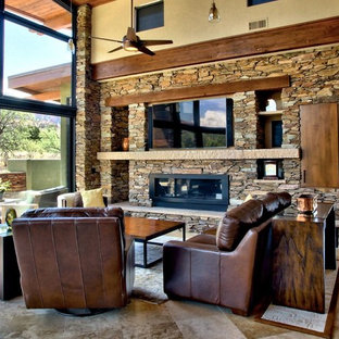 Großes, Offenes Mediterranes Wohnzimmer mit brauner Wandfarbe, Kamin, Kaminsims aus Stein, Multimediawand und Travertin in Phoenix