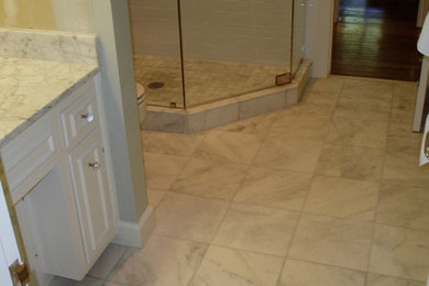Inspiration for a craftsman white tile and ceramic tile doorless shower remodel in Nashville with recessed-panel cabinets, white cabinets, marble countertops and a two-piece toilet