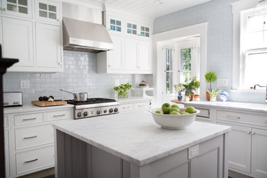Design ideas for a traditional l-shaped kitchen in New York with an undermount sink, recessed-panel cabinets, white cabinets, white splashback, subway tile splashback, stainless steel appliances, dark hardwood floors and with island.