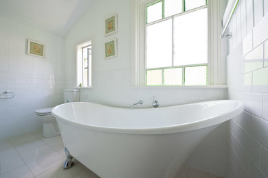 Photo of a mid-sized traditional bathroom in Brisbane with flat-panel cabinets, white cabinets, a freestanding tub, a corner shower, a two-piece toilet, white tile, subway tile, white walls, a vessel sink and a hinged shower door.