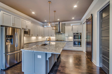 Kitchen - transitional dark wood floor kitchen idea in Nashville with an undermount sink, white cabinets, marble countertops, white backsplash, stainless steel appliances and an island
