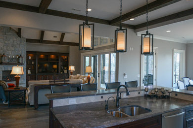 Mid-sized mountain style l-shaped dark wood floor open concept kitchen photo in Other with a double-bowl sink, raised-panel cabinets, distressed cabinets, granite countertops, beige backsplash, ceramic backsplash, stainless steel appliances and an island
