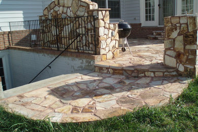 Example of a mid-sized classic backyard stone patio design in DC Metro