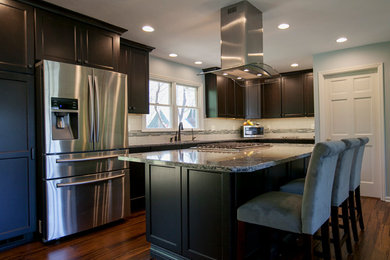 Inspiration for a mid-sized transitional single-wall bamboo floor eat-in kitchen remodel in Other with an undermount sink, recessed-panel cabinets, dark wood cabinets, solid surface countertops, white backsplash, ceramic backsplash, stainless steel appliances and an island