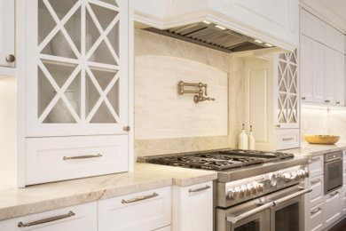 Kitchen pantry - large traditional u-shaped medium tone wood floor and brown floor kitchen pantry idea in Miami with a farmhouse sink, raised-panel cabinets, white cabinets, quartzite countertops, beige backsplash, stone slab backsplash, stainless steel appliances, an island and beige countertops