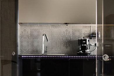 Photo of a mid-sized contemporary single-wall separate kitchen in Rome with a double-bowl sink, flat-panel cabinets, black cabinets, beige splashback, ceramic splashback, medium hardwood floors and no island.