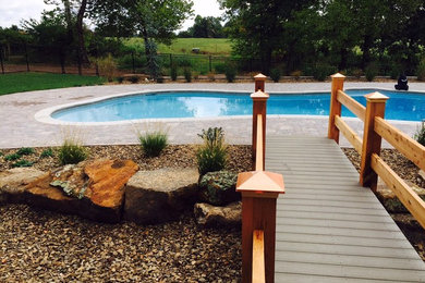 This is an example of a mid-sized arts and crafts backyard custom-shaped lap pool in Other with brick pavers.