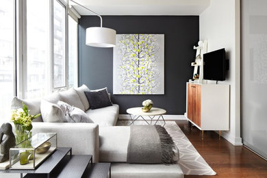 Example of a classic enclosed medium tone wood floor and brown floor living room design in Toronto with black walls, no fireplace and a wall-mounted tv
