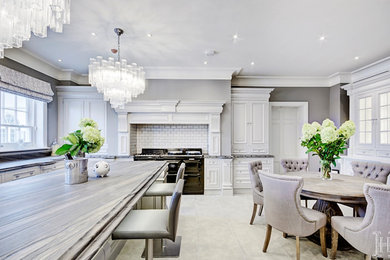 Inspiration for a transitional porcelain tile eat-in kitchen remodel in Hertfordshire with marble countertops and an island