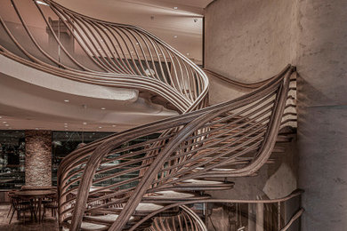 Große Stilmix Wendeltreppe mit gebeizten Holz-Treppenstufen, gebeizten Holz-Setzstufen und Mix-Geländer in London