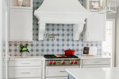 Example of a large transitional l-shaped medium tone wood floor and brown floor eat-in kitchen design in Atlanta with an undermount sink, recessed-panel cabinets, blue cabinets, quartz countertops, blue backsplash, cement tile backsplash, stainless steel appliances, an island and beige countertops