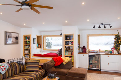 Inspiration for a large country enclosed carpeted, gray floor and vaulted ceiling family room remodel in Other with a bar, white walls, a standard fireplace, a stacked stone fireplace and a wall-mounted tv
