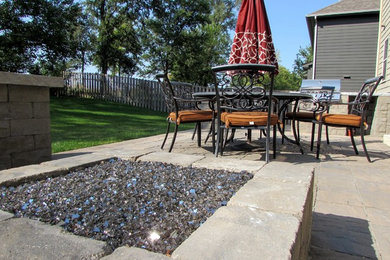 Large elegant backyard stone patio photo in Other with a fire pit and no cover