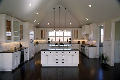 Example of a large trendy u-shaped brown floor and dark wood floor eat-in kitchen design in Boston with white cabinets, white backsplash, stainless steel appliances, two islands, shaker cabinets and a farmhouse sink
