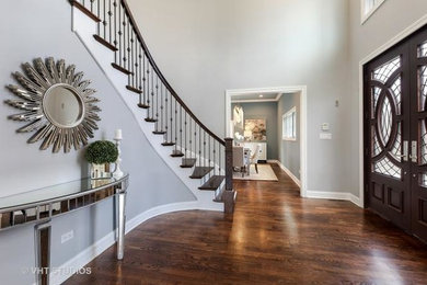 Photo of a medium sized traditional foyer in Chicago with grey walls, medium hardwood flooring, a double front door, a dark wood front door and brown floors.