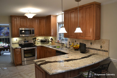 Example of a trendy u-shaped kitchen design in Raleigh with a double-bowl sink, raised-panel cabinets, medium tone wood cabinets, granite countertops, beige backsplash, ceramic backsplash and stainless steel appliances
