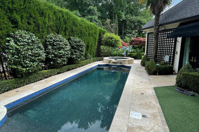 Foto de piscinas y jacuzzis alargados de tamaño medio rectangulares en patio trasero con adoquines de piedra natural
