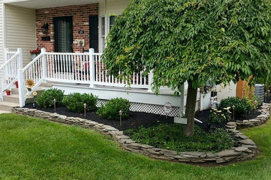 This is an example of a mid-sized traditional drought-tolerant and partial sun front yard stone lawn edging in Philadelphia.