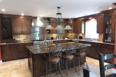 Eat-in kitchen - mid-sized rustic l-shaped porcelain tile and beige floor eat-in kitchen idea in New York with an undermount sink, flat-panel cabinets, dark wood cabinets, granite countertops, beige backsplash, stone tile backsplash, stainless steel appliances and an island