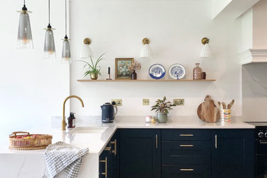 Foto de cocina actual con armarios estilo shaker, salpicadero de losas de piedra y encimeras blancas