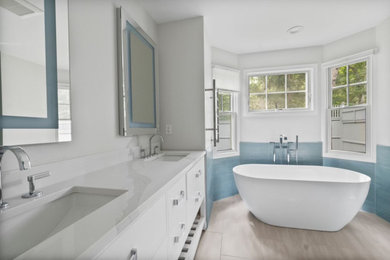 Inspiration for a mid-sized contemporary master blue tile and porcelain tile ceramic tile, gray floor and double-sink bathroom remodel in Boston with shaker cabinets, white cabinets, a bidet, gray walls, an undermount sink, quartz countertops, a hinged shower door, white countertops and a freestanding vanity